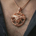 Load image into Gallery viewer, Rose gold plated bad dream catcher pendant necklace worn on the neck, presented in a close-up lifestyle shot with a refined masculine aesthetic.

