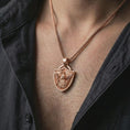 Load image into Gallery viewer, Rose gold plated Fortiores Una eagle shield pendant necklace worn on the neck, presented in a close-up lifestyle shot with a refined masculine aesthetic.
