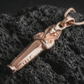 Load image into Gallery viewer, Rose gold plated King Tut pendant necklace on dark volcanic rock, photographed in a detailed premium studio macro view.
