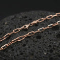 Load image into Gallery viewer, Rose gold plated cable link chain necklace on dark volcanic rock, photographed in a detailed premium studio macro view.
