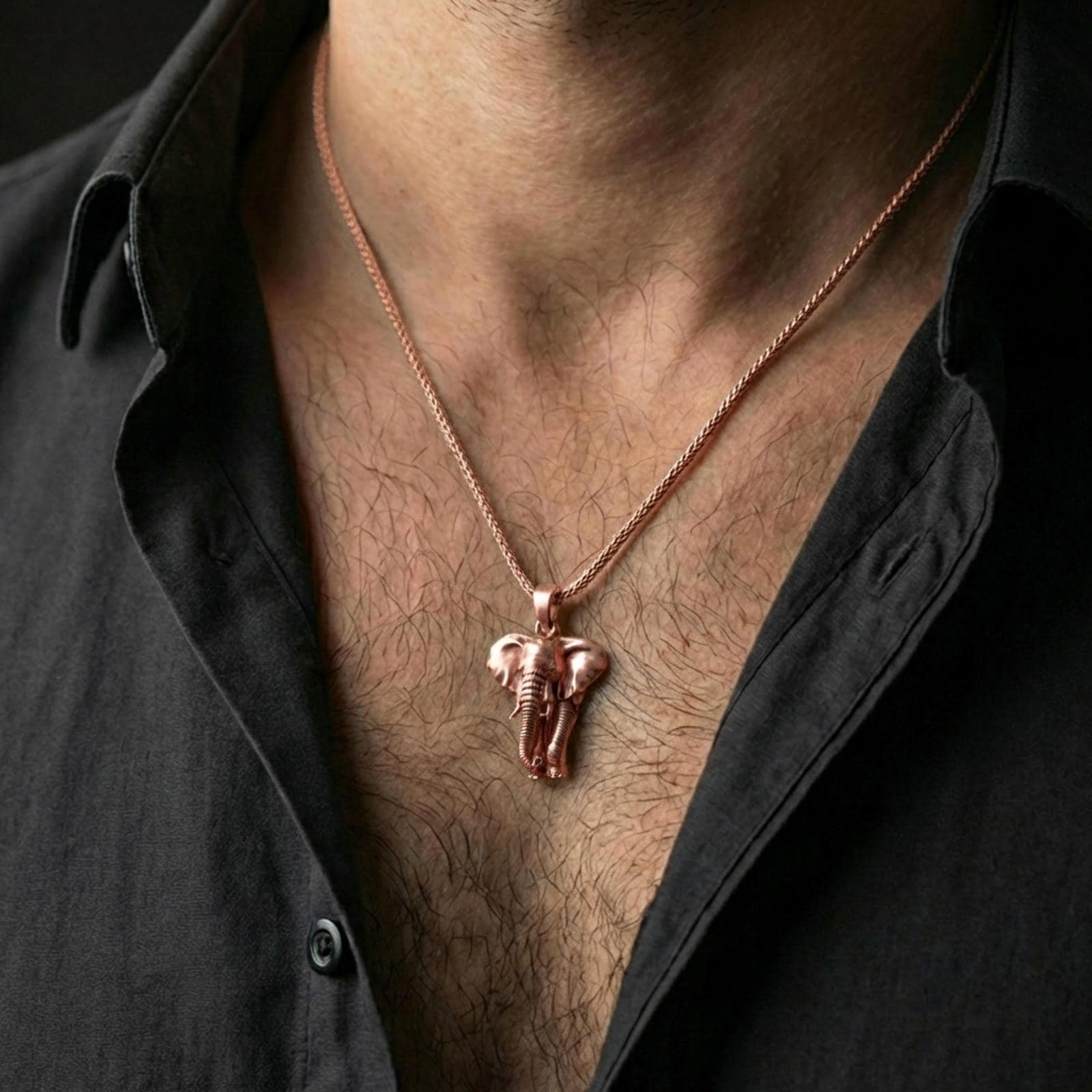 Rose gold plated elephant pendant necklace worn on the neck, presented in a close-up lifestyle shot with a refined masculine aesthetic.