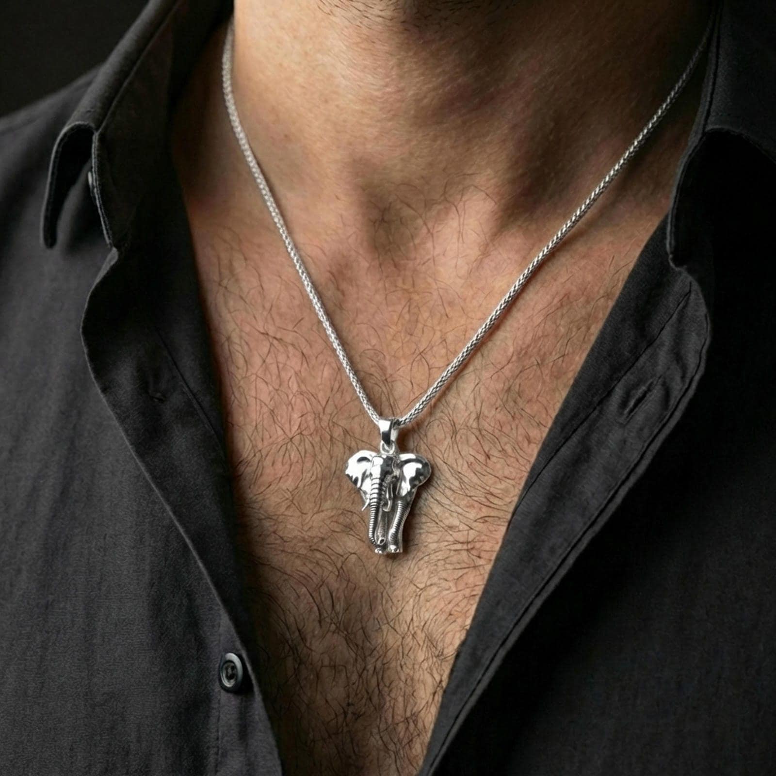 Polished silver elephant pendant necklace worn on the neck, shown against the chest in a clean and elegant everyday wear composition.