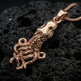 Load image into Gallery viewer, Rose gold plated octopus pendant necklace on dark volcanic rock, photographed in a detailed premium studio macro view.
