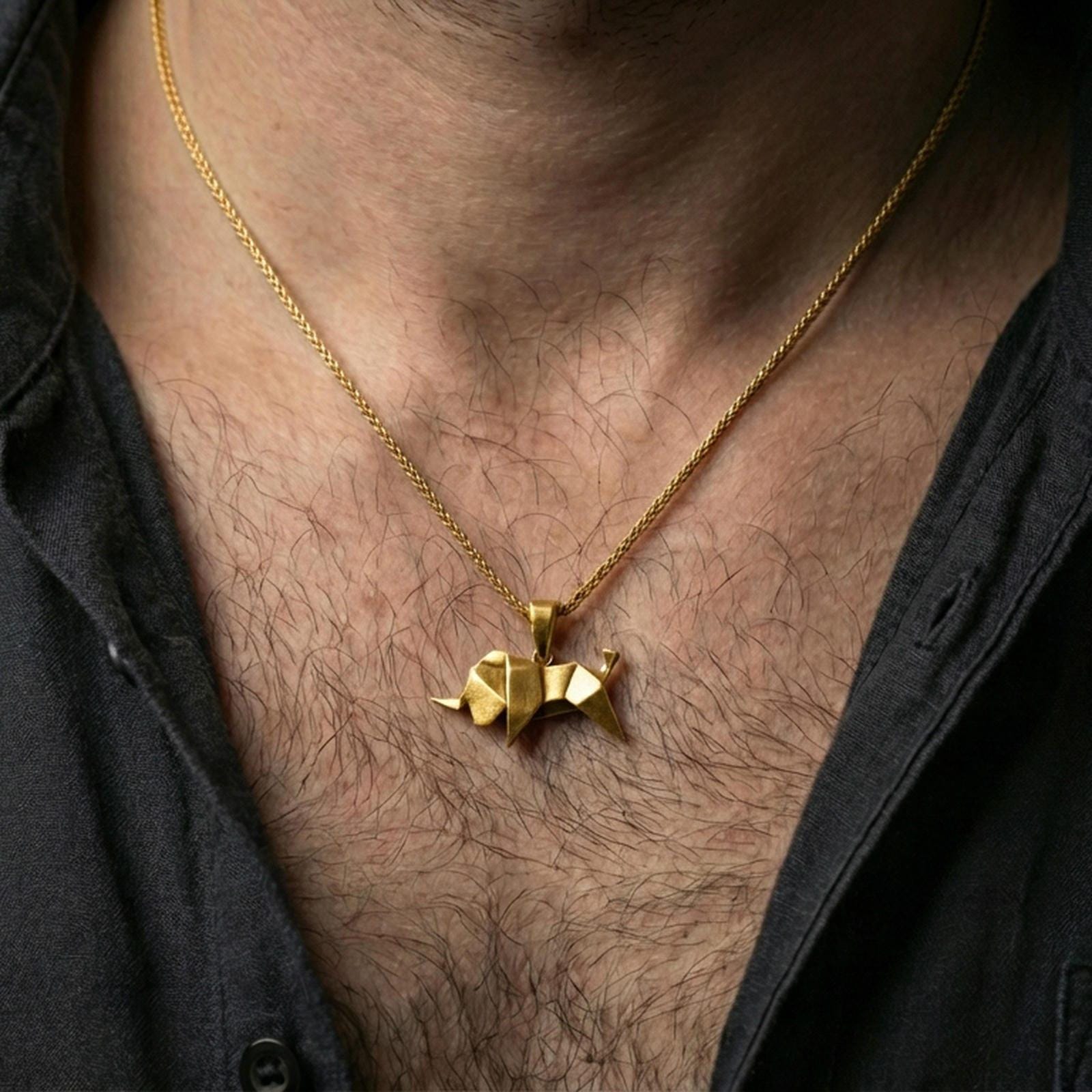 Gold plated origami elephant pendant necklace worn on the neck, captured on a human model in a premium dark-toned lifestyle frame.