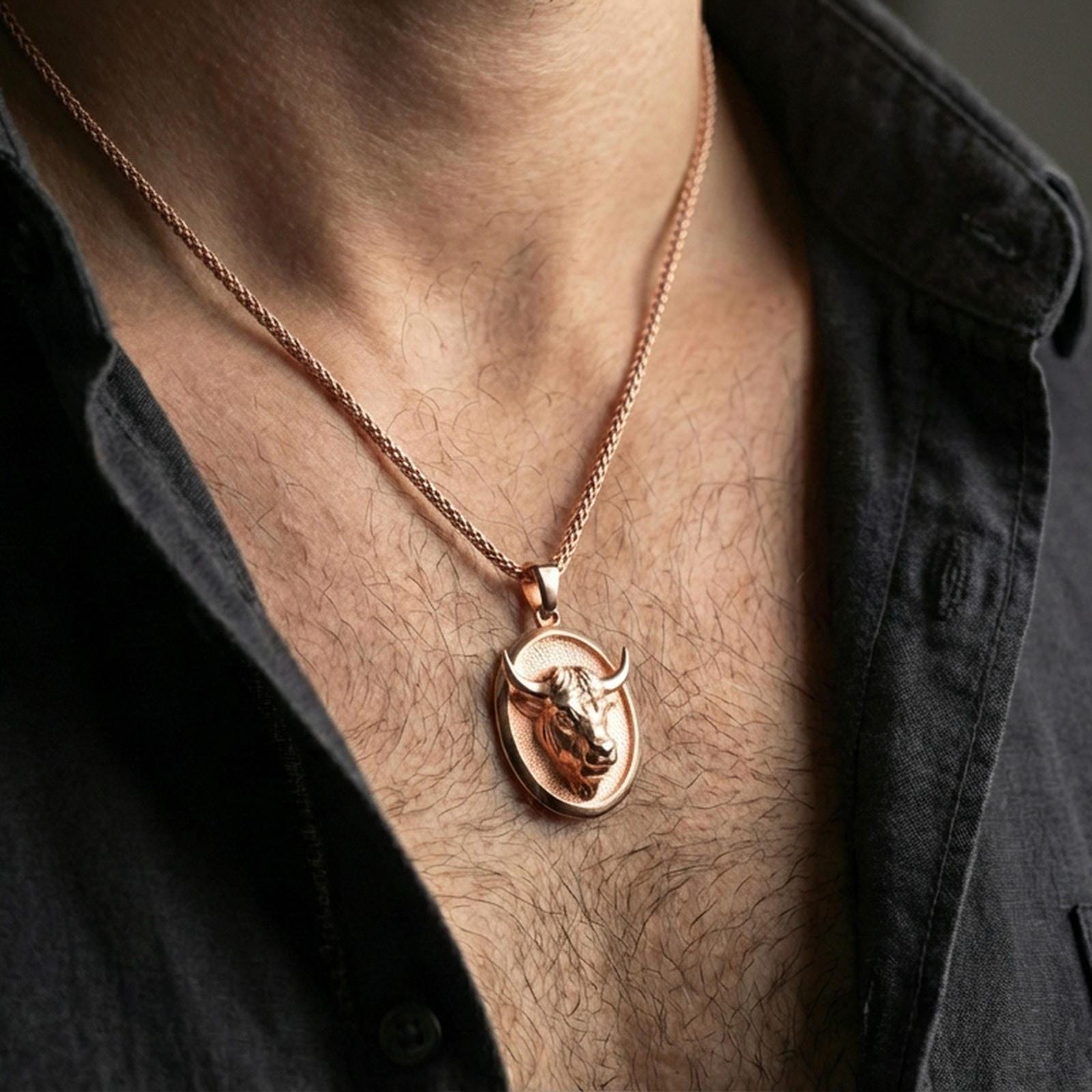 Rose gold plated bull pendant necklace worn on the neck, presented in a close-up lifestyle shot with a refined masculine aesthetic.