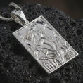Load image into Gallery viewer, Polished silver mermaid pendant necklace displayed on black volcanic rock, shown in a refined macro product shot with detailed siren figure and flowing underwater relief.
