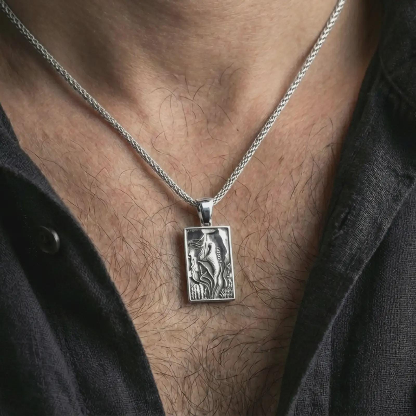 Polished silver mermaid pendant necklace worn on the neck, shown against the chest in a clean and elegant everyday wear composition.