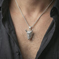 Load image into Gallery viewer, Polished silver Oni mask pendant necklace worn on the neck, shown against the chest in a clean and dramatic everyday wear composition.
