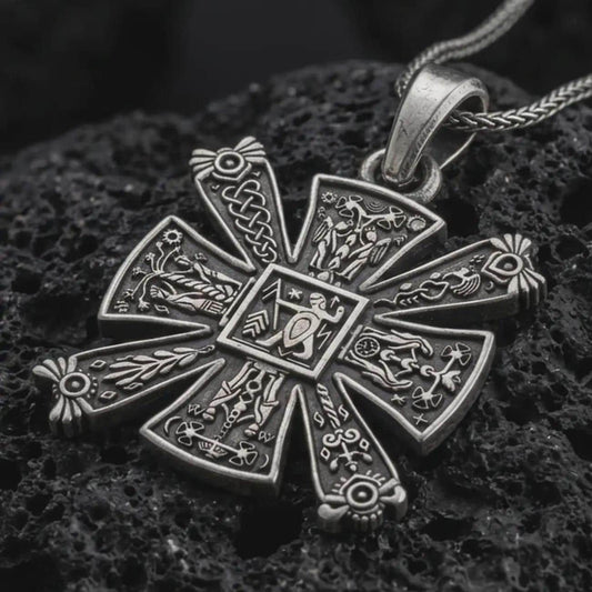 Sterling silver Norse Celtic cross pendant with an oxidized finish resting on textured volcanic rock, captured in a close-up premium studio composition.