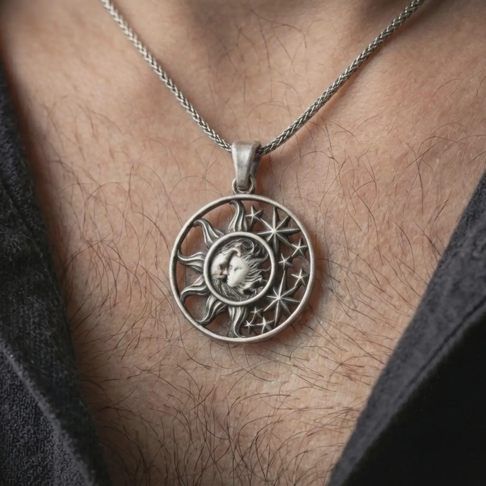 Oxidized sun and moon pendant necklace worn on the neck, styled in a dark lifestyle portrait with an open shirt and masculine presentation.