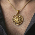 Load image into Gallery viewer, Gold plated sun and moon pendant necklace worn on the neck, captured on a human model in a premium dark-toned lifestyle frame.
