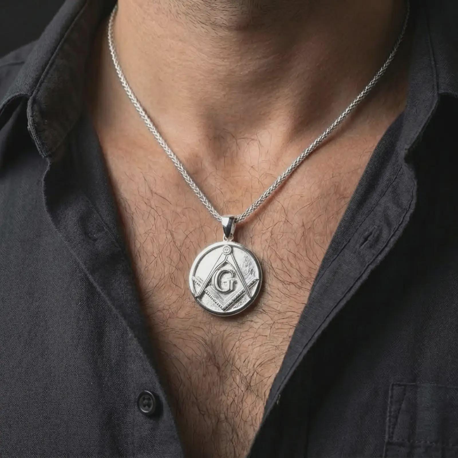 Polished silver Masonic emblem pendant necklace worn on the neck, shown against the chest in a clean and elegant everyday wear composition.