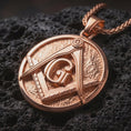 Load image into Gallery viewer, Rose gold plated Masonic emblem pendant necklace on dark volcanic rock, photographed in a detailed premium studio macro view.
