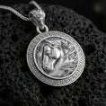 Load image into Gallery viewer, Polished silver horse head pendant necklace displayed on black volcanic rock, shown in a refined macro product shot with Greek key border detail.
