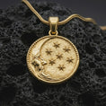 Load image into Gallery viewer, Gold plated moon and stars pendant necklace presented on porous volcanic rock, highlighting the round cosmic medallion design in a luxurious close-up jewelry image.
