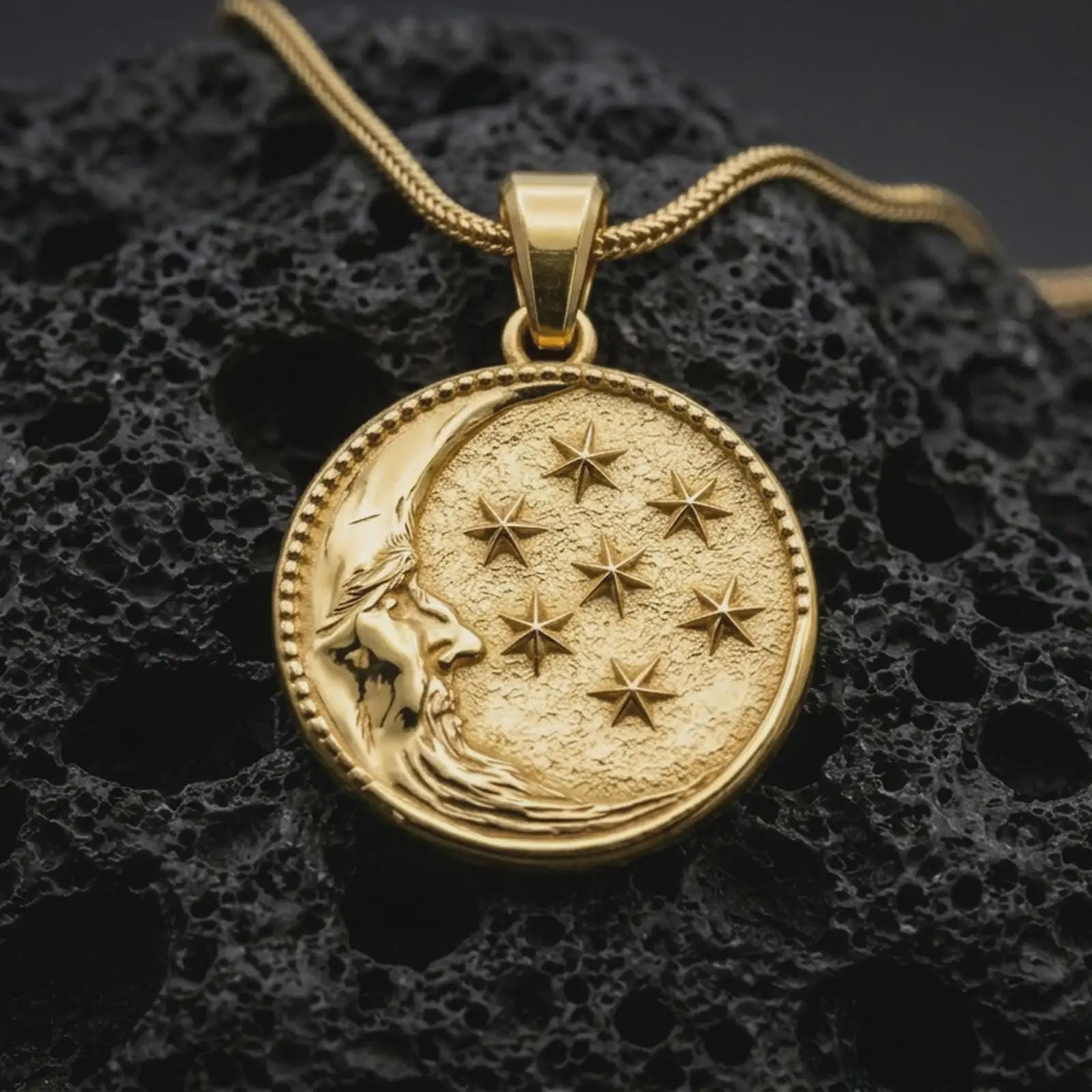 Gold plated moon and stars pendant necklace presented on porous volcanic rock, highlighting the round cosmic medallion design in a luxurious close-up jewelry image.