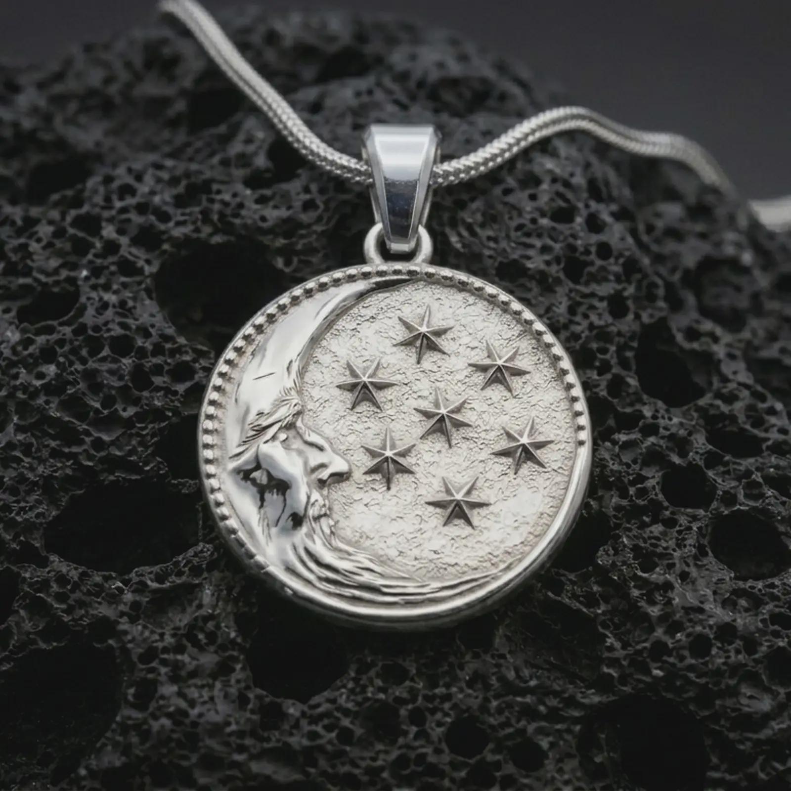 Polished silver moon and stars pendant necklace displayed on black volcanic rock, shown in a refined macro product shot with crescent moon face and celestial star relief.