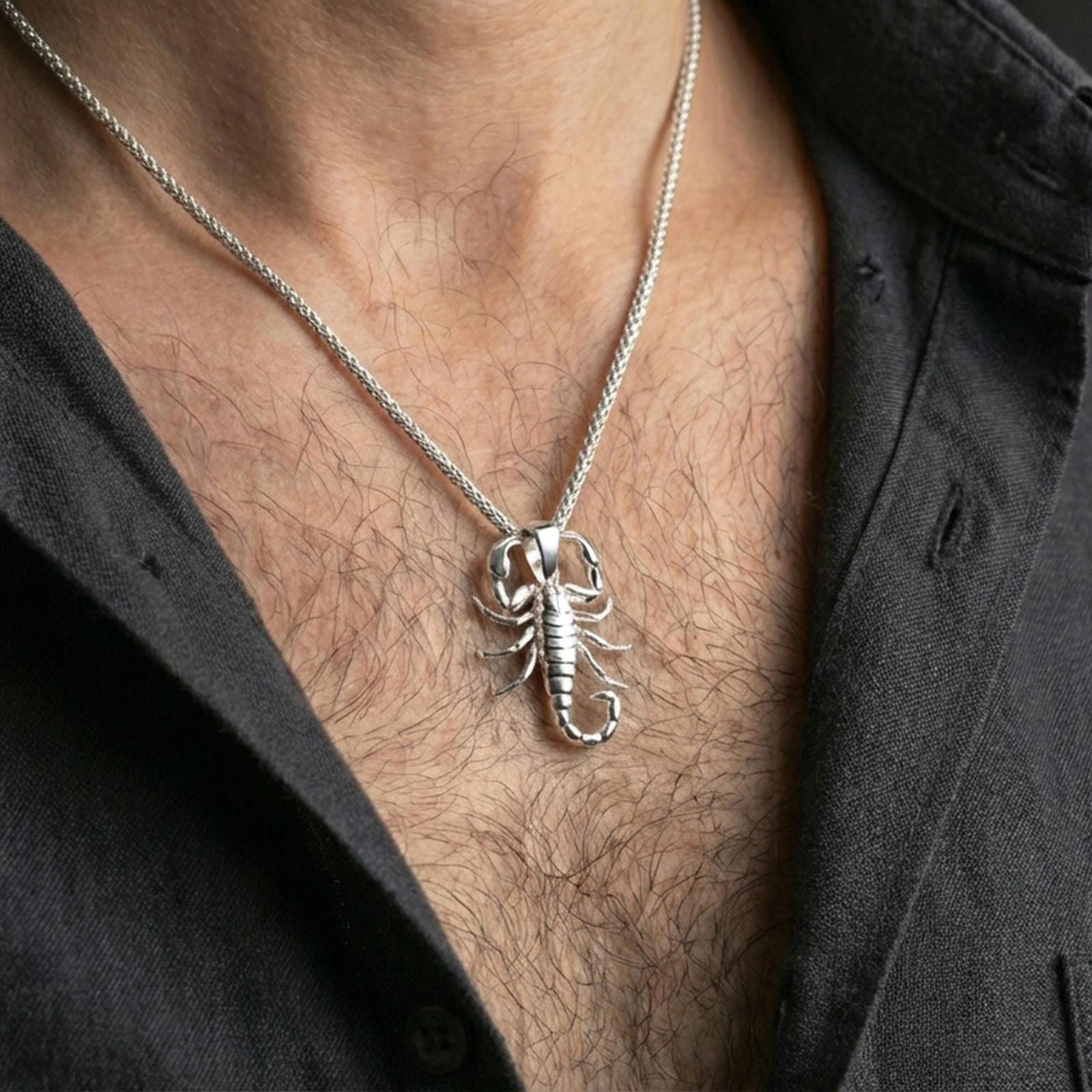 Polished silver scorpion pendant necklace worn on the neck, shown against the chest in a clean and elegant everyday wear composition.