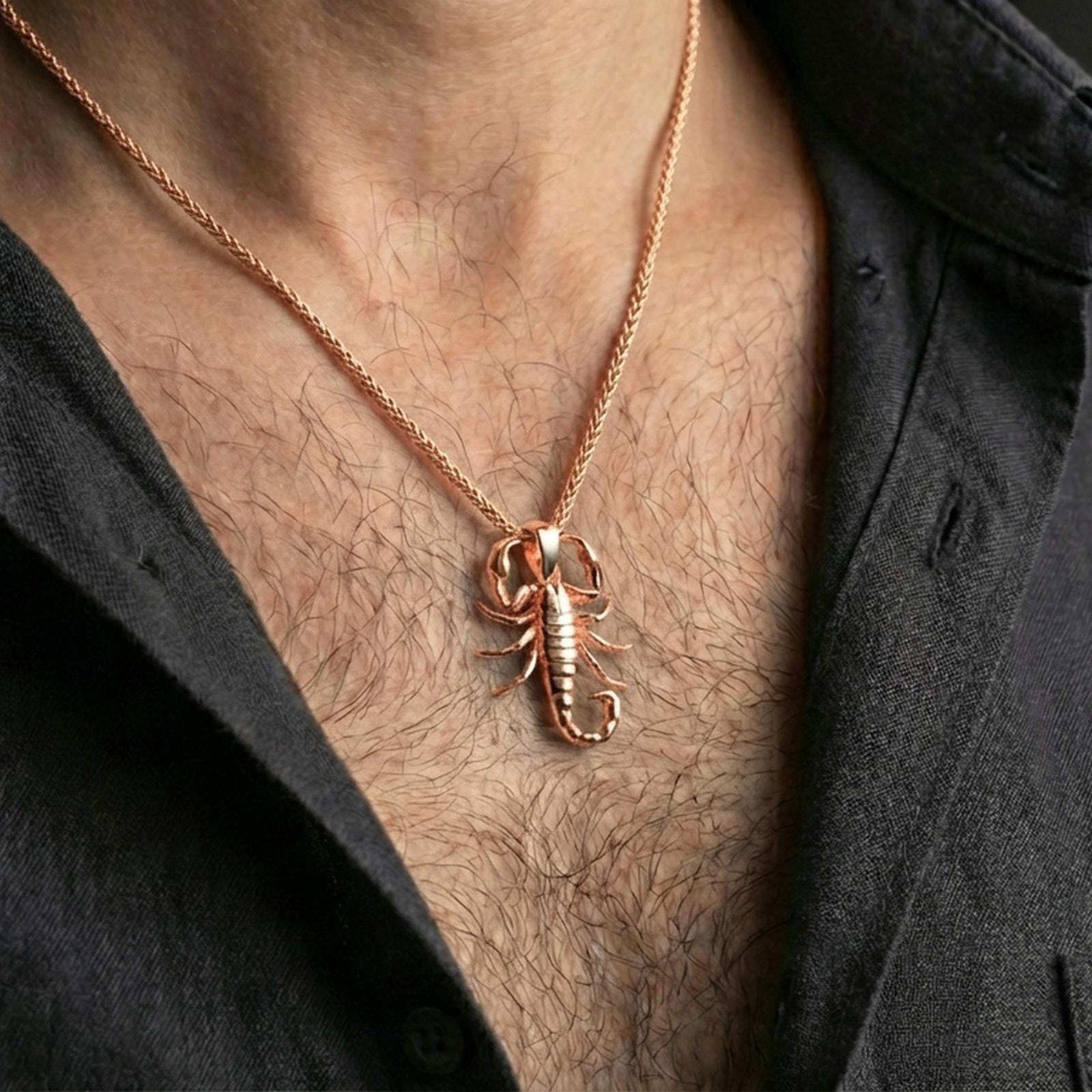 Rose gold plated scorpion pendant necklace worn on the neck, presented in a close-up lifestyle shot with a refined masculine aesthetic.