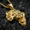 Load image into Gallery viewer, Gold plated lion head pendant necklace presented on porous volcanic rock, highlighting the bold safari-inspired animal design in a luxurious close-up jewelry image.

