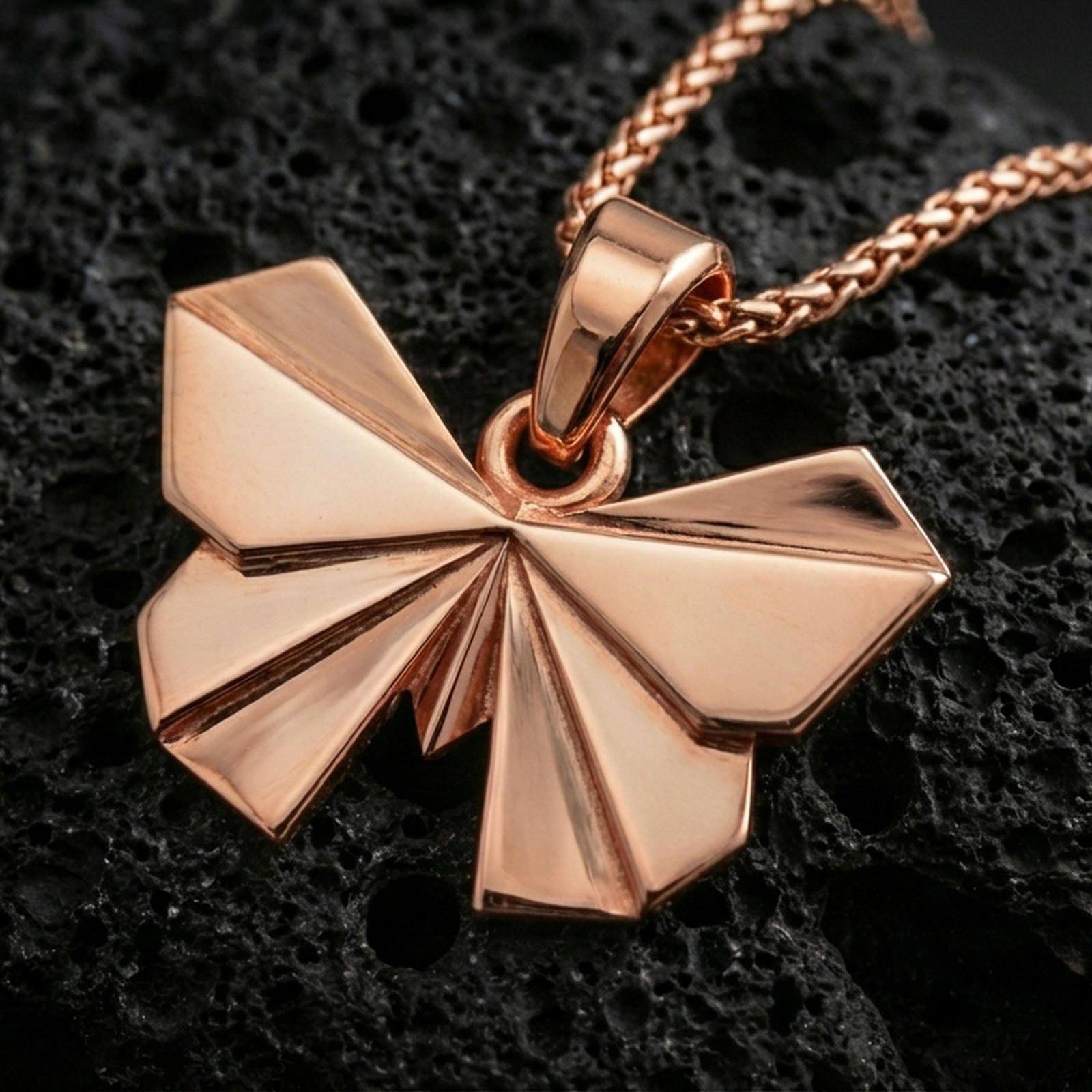 Rose gold plated origami butterfly pendant necklace on dark volcanic rock, photographed in a detailed premium studio macro view.