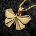 Load image into Gallery viewer, Gold plated origami butterfly pendant necklace presented on porous volcanic rock, highlighting the geometric insect silhouette in a luxurious close-up jewelry image.
