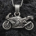 Load image into Gallery viewer, Sterling silver sportbike motorcycle pendant necklace with an oxidized finish resting on textured volcanic rock, captured in a close-up premium studio composition.

