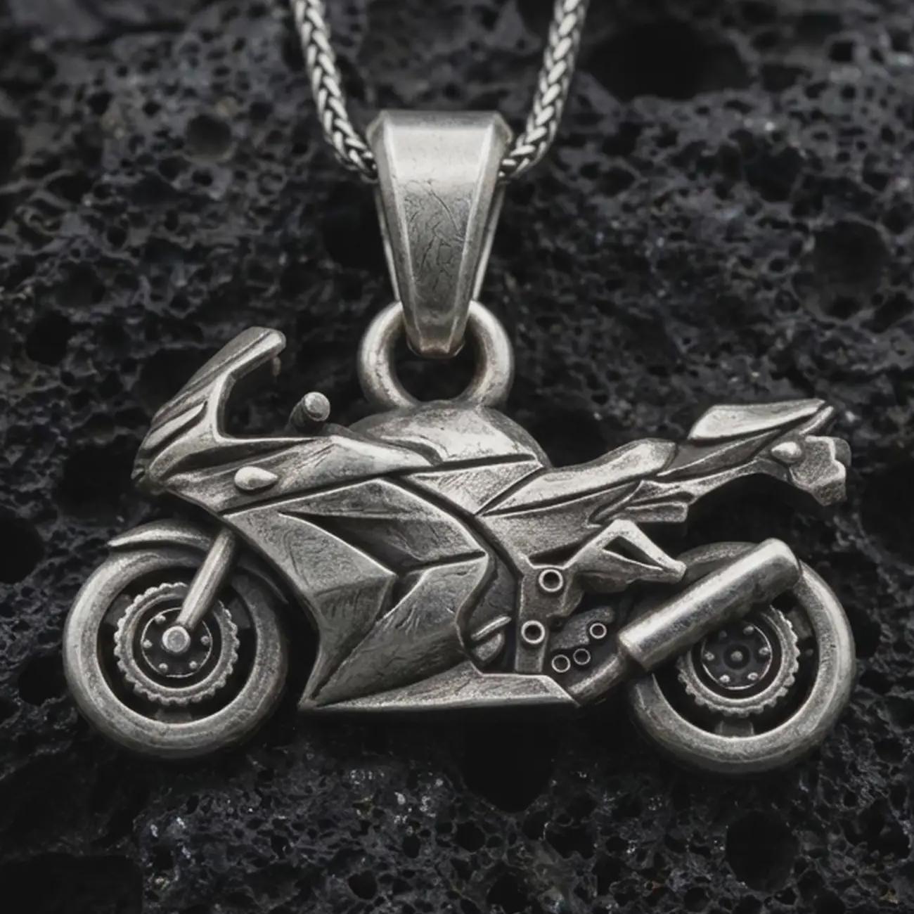 Sterling silver sportbike motorcycle pendant necklace with an oxidized finish resting on textured volcanic rock, captured in a close-up premium studio composition.