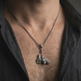 Load image into Gallery viewer, Oxidized paladin hammer pendant necklace worn on the neck, styled in a dark lifestyle portrait with an open shirt and masculine presentation.
