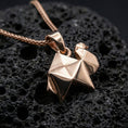 Load image into Gallery viewer, Rose gold plated origami camel pendant necklace on dark volcanic rock, photographed in a detailed premium studio macro view.
