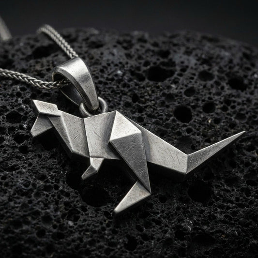 Sterling silver origami kangaroo pendant necklace with an oxidized finish resting on textured volcanic rock, captured in a close-up premium studio composition.