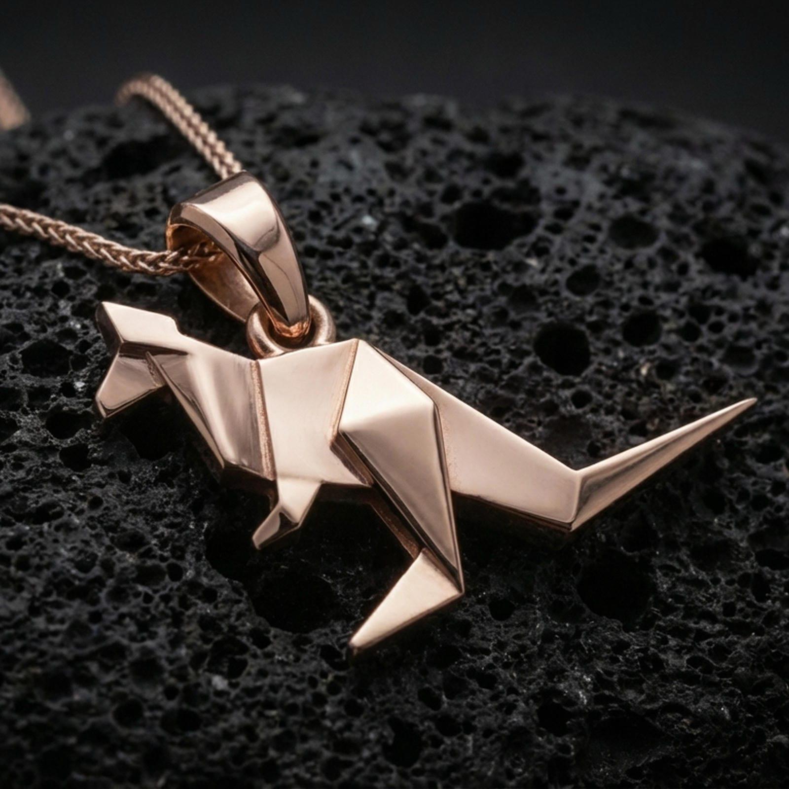 Rose gold plated origami kangaroo pendant necklace on dark volcanic rock, photographed in a detailed premium studio macro view.