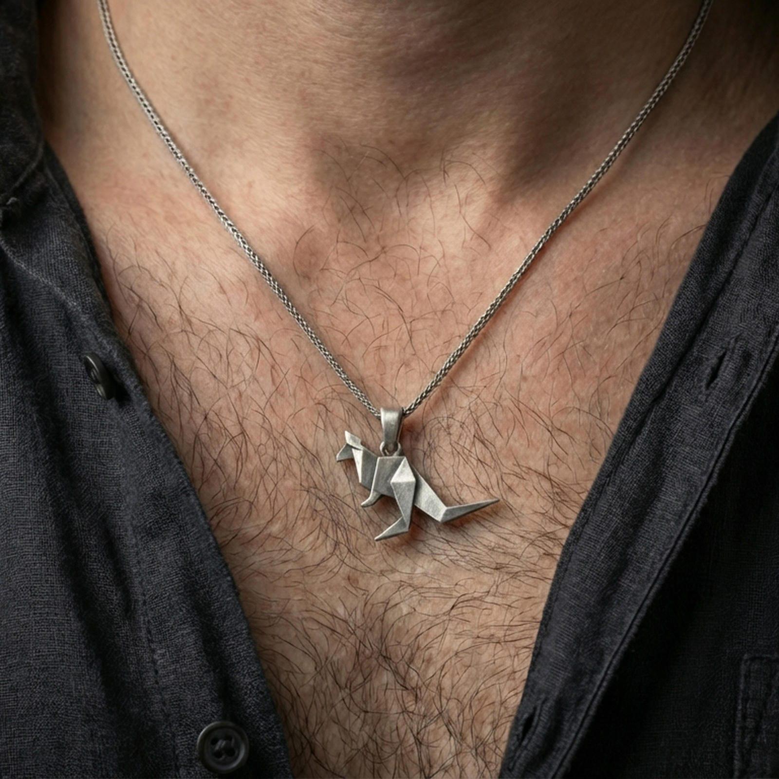 Oxidized origami kangaroo pendant necklace worn on the neck, styled in a dark lifestyle portrait with an open shirt and masculine presentation.