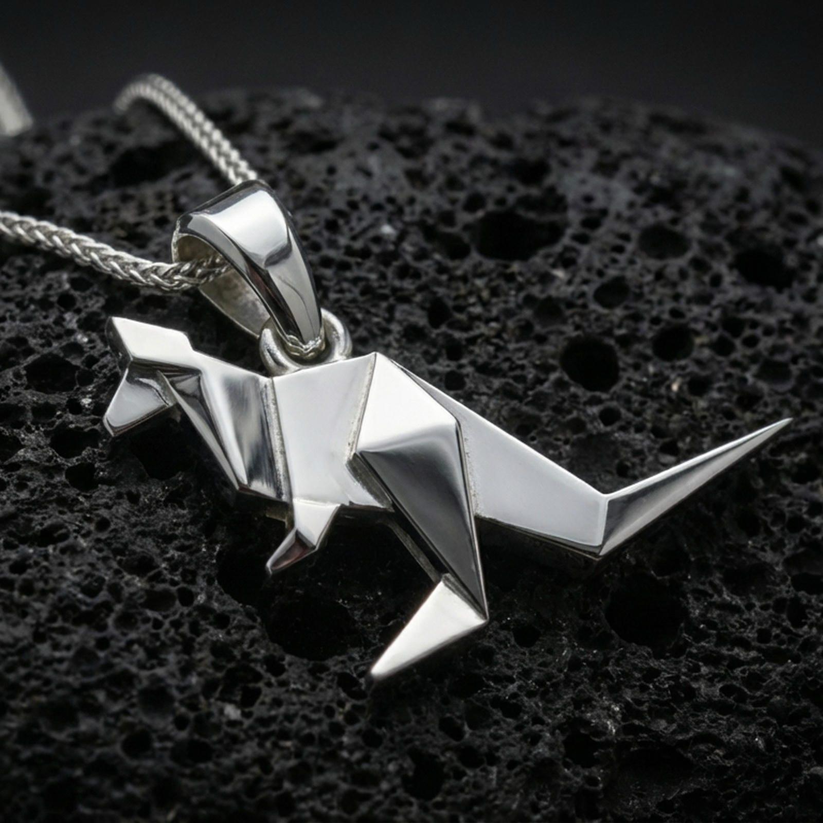 Polished silver origami kangaroo pendant necklace displayed on black volcanic rock, shown in a refined macro product shot with crisp folded geometric detail.