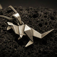 Load image into Gallery viewer, Bronze origami kangaroo pendant necklace with an oxidized finish resting on textured volcanic rock, captured in a close-up premium studio composition.

