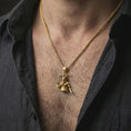 Load image into Gallery viewer, Gold plated Baphomet pendant necklace worn on the neck, captured on a human model in a premium dark-toned lifestyle frame.
