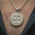 Load image into Gallery viewer, Polished silver Celtic knot medallion necklace worn on the neck, shown against the chest in a clean and elegant everyday wear composition.
