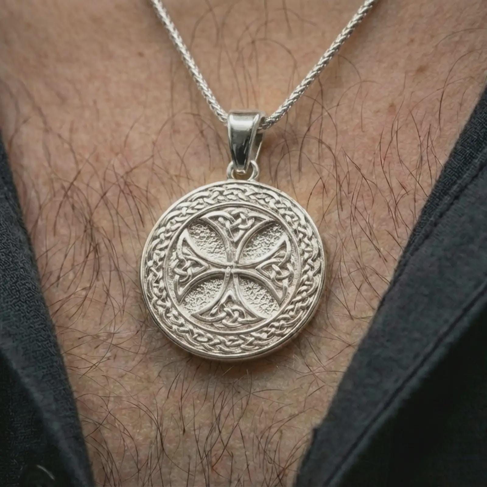 Polished silver Celtic knot medallion necklace worn on the neck, shown against the chest in a clean and elegant everyday wear composition.