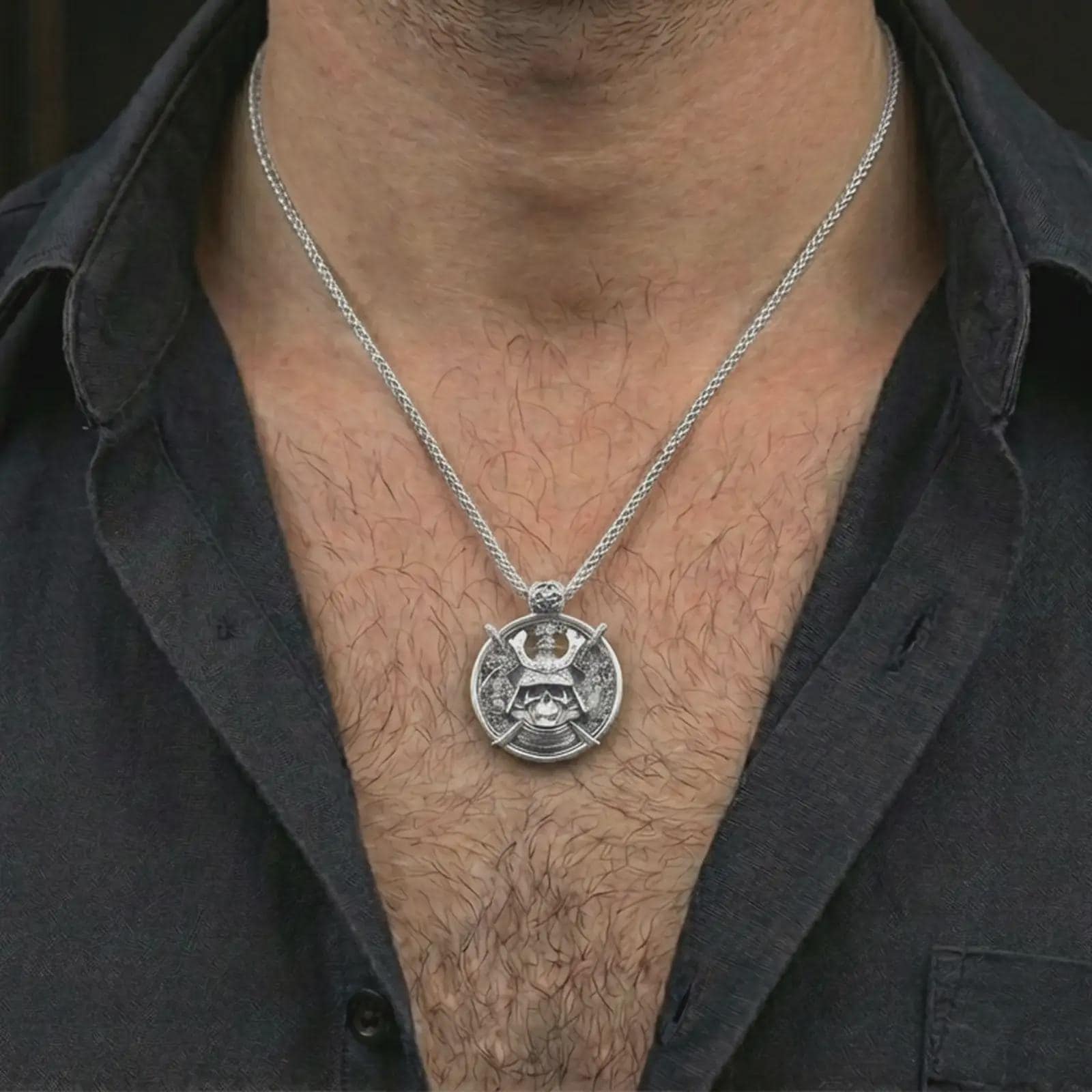 Polished silver samurai skull pendant necklace worn on the neck, shown against the chest in a clean and dramatic everyday wear composition.