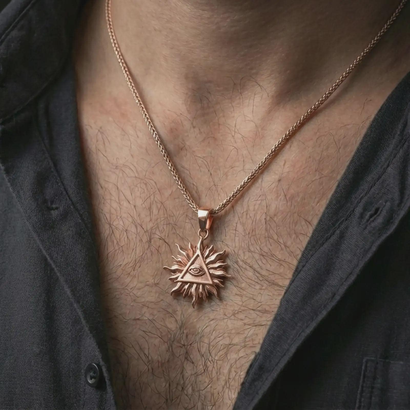 Rose gold plated Eye of Providence sun pendant necklace worn on the neck, presented in a close-up lifestyle shot with a refined masculine aesthetic.