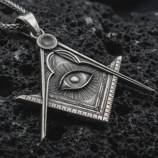 Sterling silver Master Mason pendant necklace with an oxidized finish resting on textured volcanic rock, captured in a close-up premium studio composition.