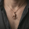 Load image into Gallery viewer, Rose gold plated Mythosaur skull pendant necklace worn on the neck, presented in a close-up lifestyle shot with a refined sci-fi aesthetic.
