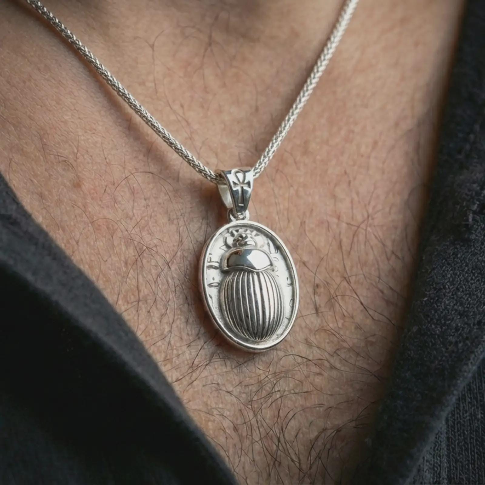 Polished silver Egyptian scarab pendant necklace worn on the neck, shown against the chest in a clean and elegant everyday wear composition.