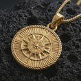 Load image into Gallery viewer, Gold plated steampunk compass pendant necklace presented on porous volcanic rock, highlighting the round navigation medallion design in a luxurious close-up jewelry image.
