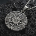 Load image into Gallery viewer, Sterling silver steampunk compass pendant necklace with an oxidized finish resting on textured volcanic rock, captured in a close-up premium studio composition.
