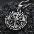 Load image into Gallery viewer, Sterling silver compass rose pendant necklace with an oxidized finish resting on textured volcanic rock, captured in a close-up premium studio composition.
