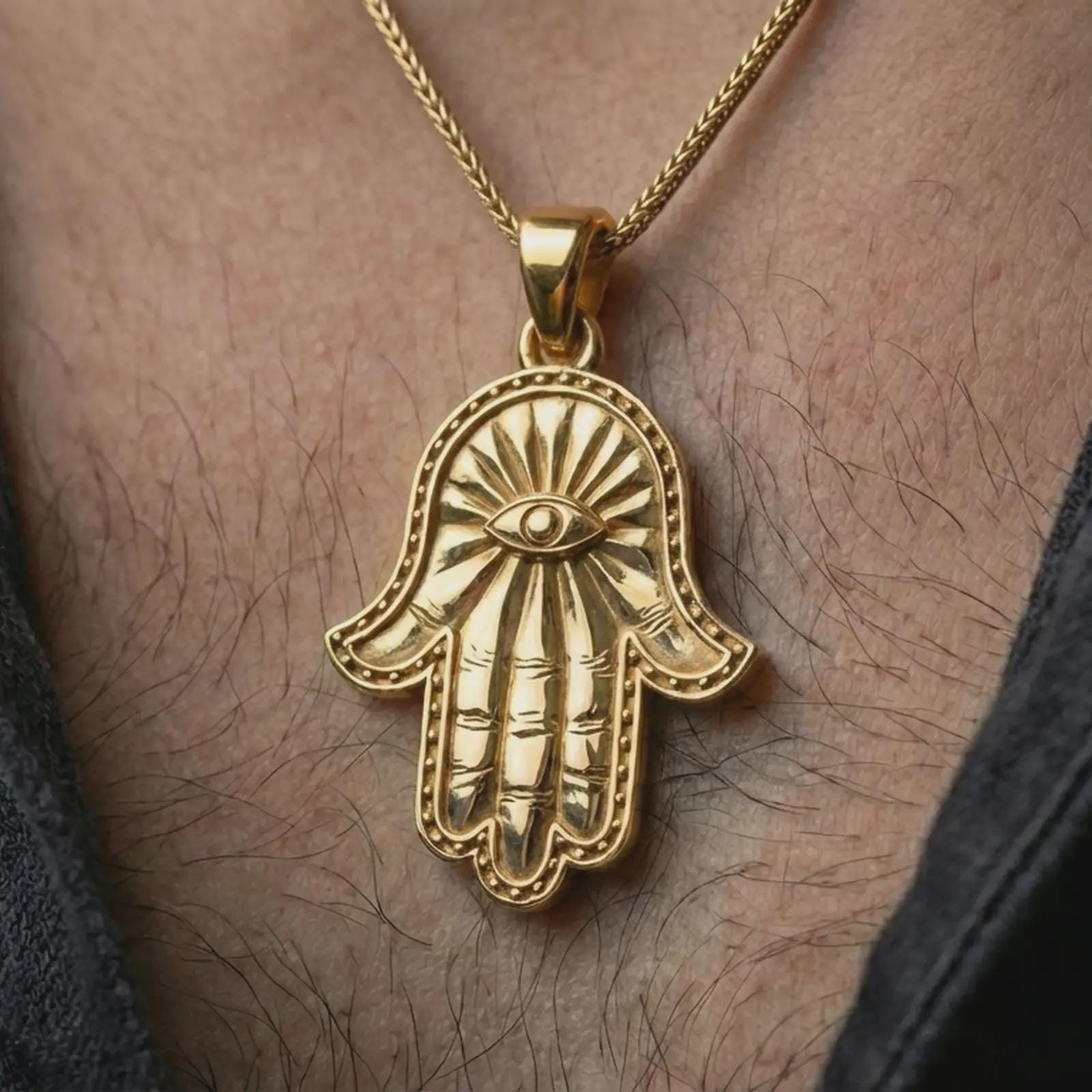 Gold plated Hamsa hand pendant necklace worn on the neck, captured on a human model in a premium dark-toned lifestyle frame.