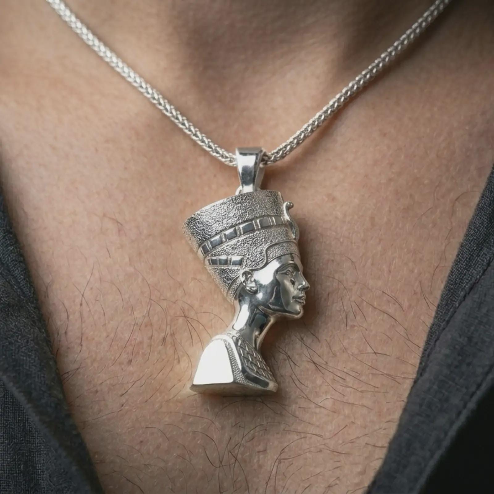 Polished silver Nefertiti pendant necklace worn on the neck, shown against the chest in a clean and graceful everyday wear composition.