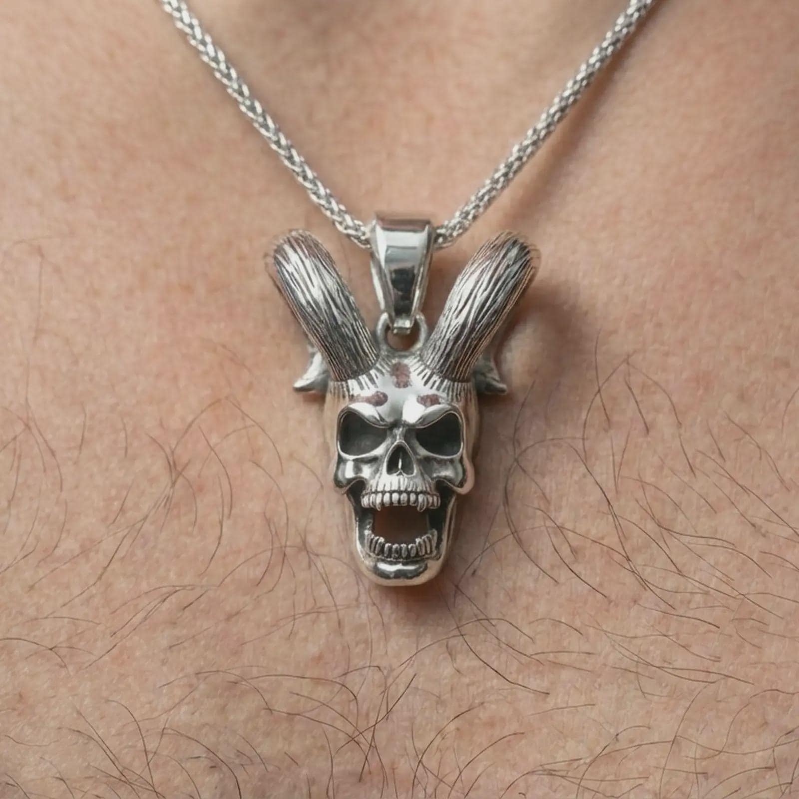Polished silver rabbit skull pendant necklace worn on the neck, shown against the chest in a clean and dramatic everyday wear composition.