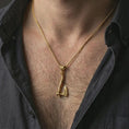 Load image into Gallery viewer, Gold plated battle axe pendant necklace worn on the neck, captured on a human model in a premium dark-toned lifestyle frame.
